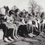 Bilde er tatt i februar 1961. Våren har alt gjort sitt inntog på Jæren. På bilde ser vi 4.kl. jenter ved Tasta Skole som koser seg med handarbeid under åpen himmel. Februarsola varmer godt, og det
grønskas og gror.
Fra venstre: Astri Aartun - Bente Hidle - Greta Aartun - Gunn Margrethe Haugsland - Judit Marie Hamre
Astrid Selvåg - Gerd Lillian Langerud - Wenche Torkildsen - Anne Grete Bjørnsen.